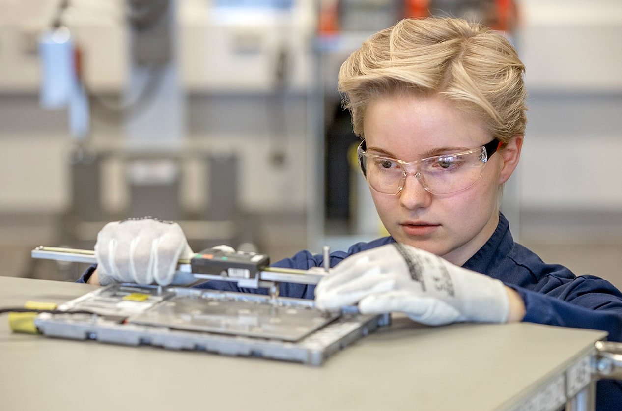 A woman wearing protective glasses at a battery factory